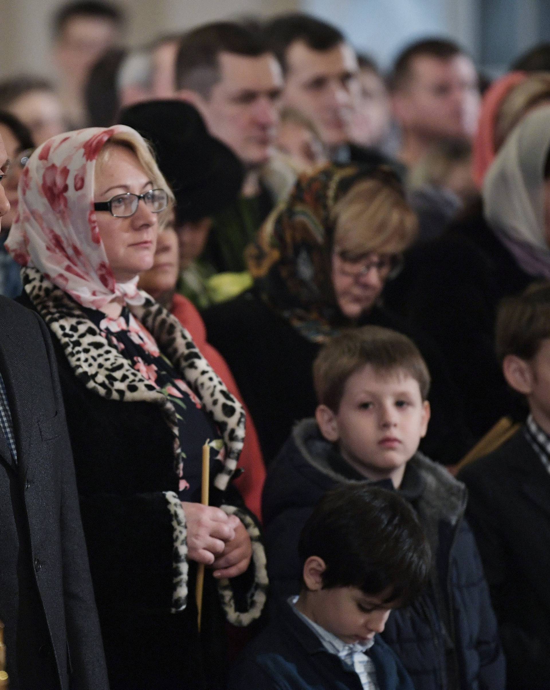 Russian President Vladimir Putin attends a service on Orthodox Christmas at the Church of Saints Simeon and Anna in St. Petersburg