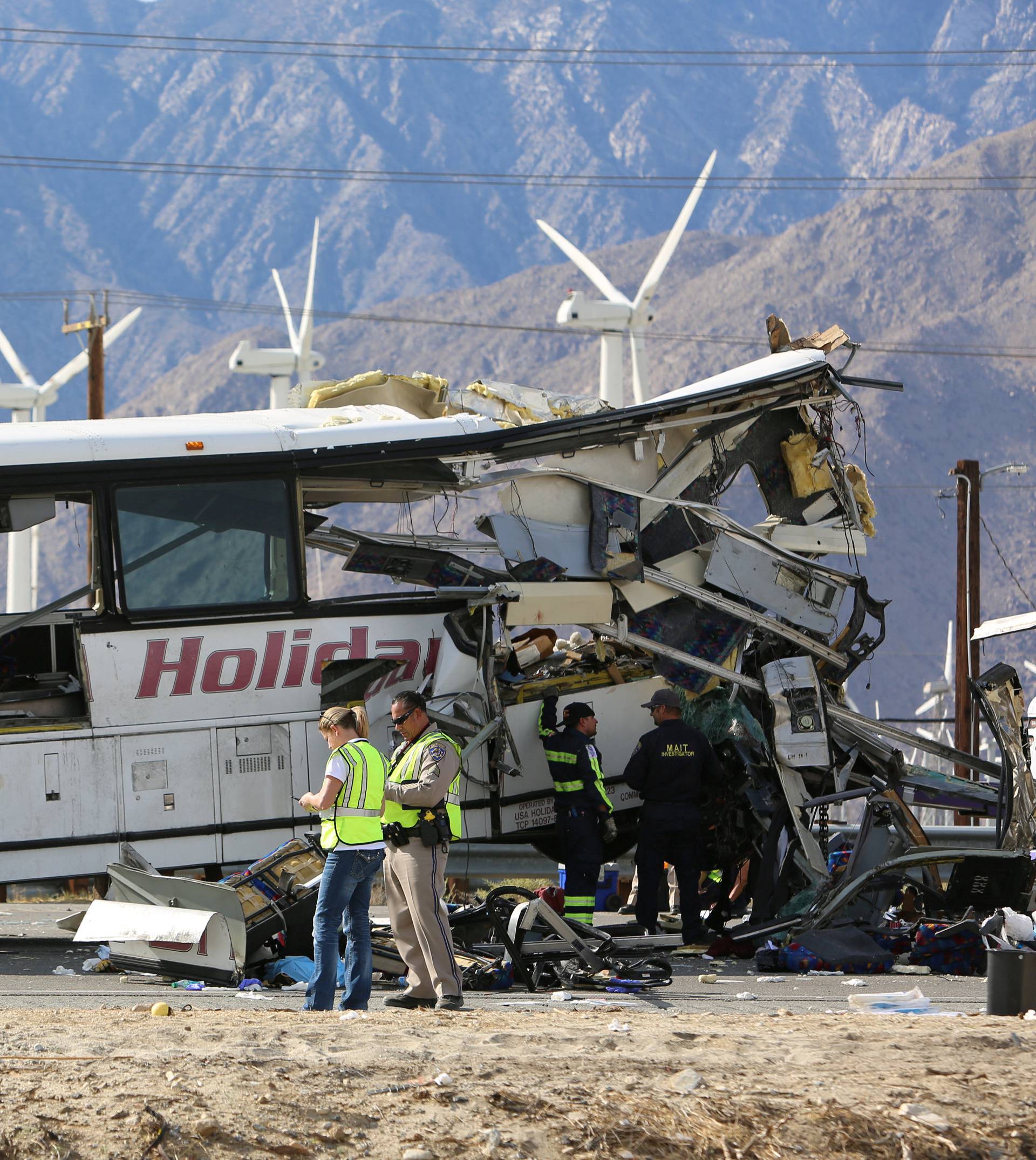 Investigators confer at the scene of a mass casualty bus crash on the westbound Interstate 10 freeway near Palm Springs, California