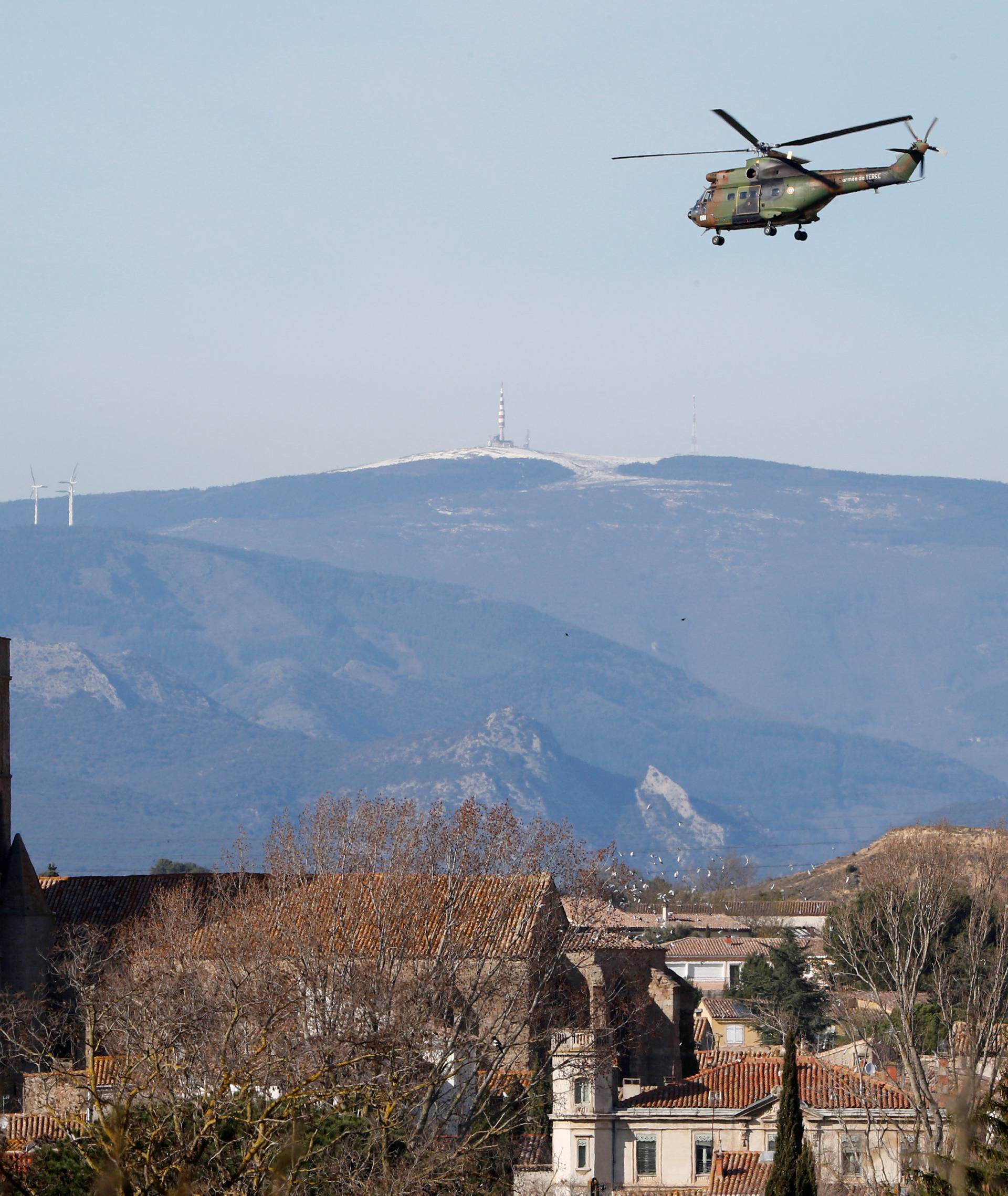 A military helicopter flies over the village of Trebes after a hostage situation in a supermarket