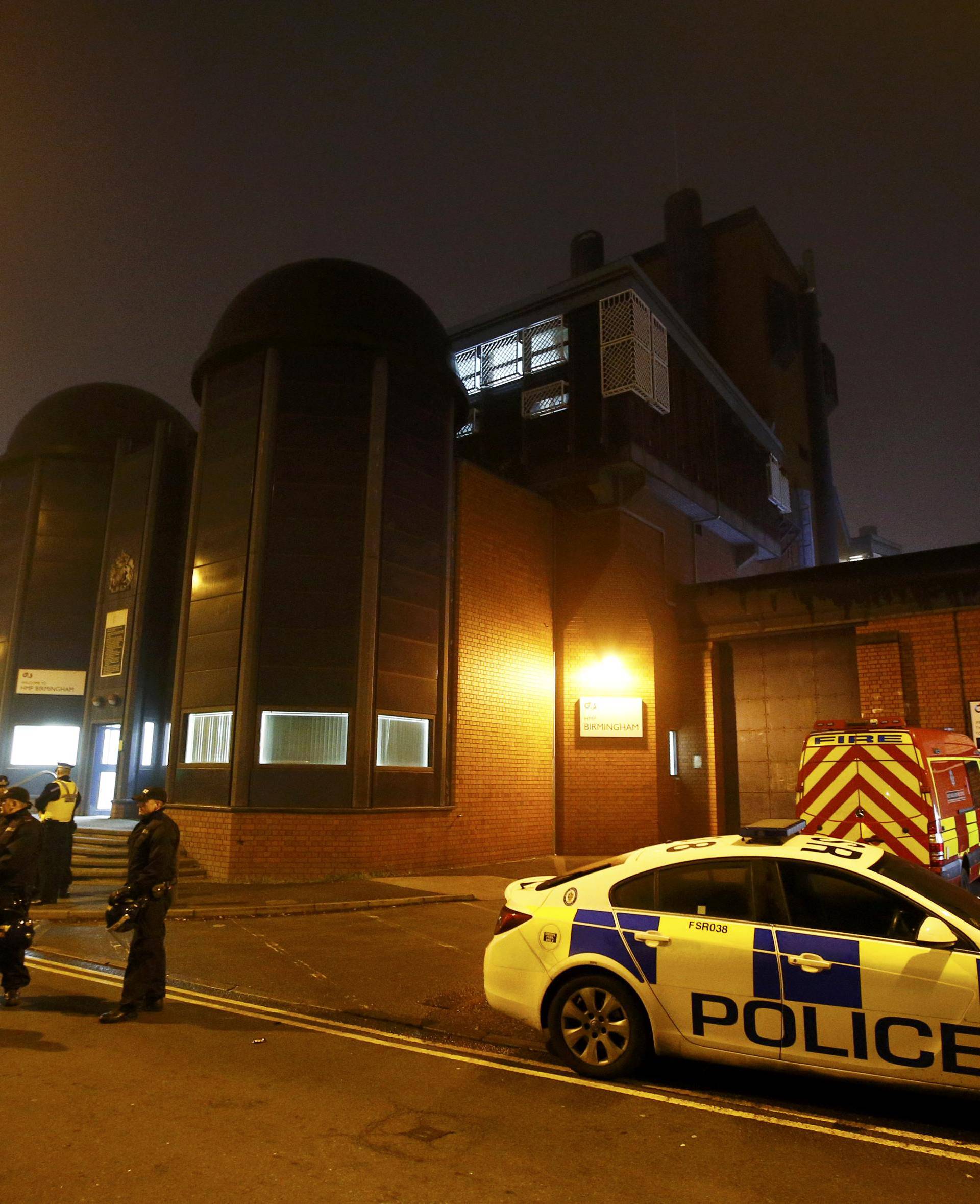 Police officers and firemen stand outside Winson Green prison, run by security firm G4S, after a serious disturbance broke out, in Birmingham
