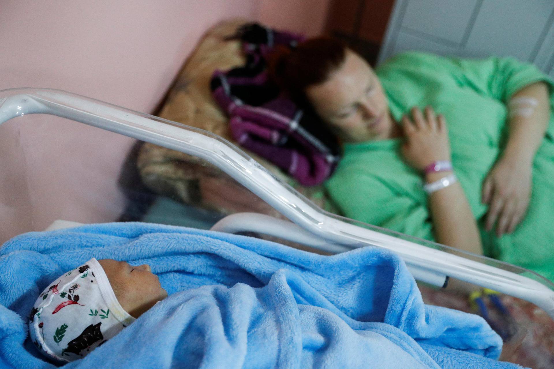 A baby is seen sleeping as patients take shelter in the basement of a perinatal centre as air raid siren sounds are heard amid Russia's invasion of Ukraine, in Kyiv