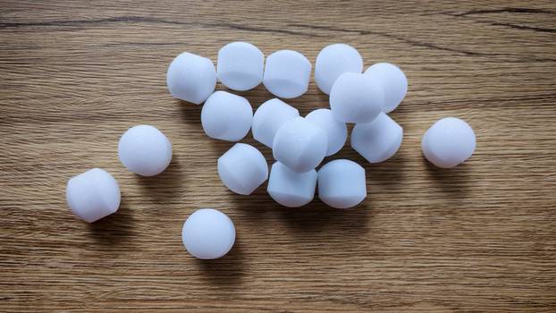 White naphthalene balls on blue background.