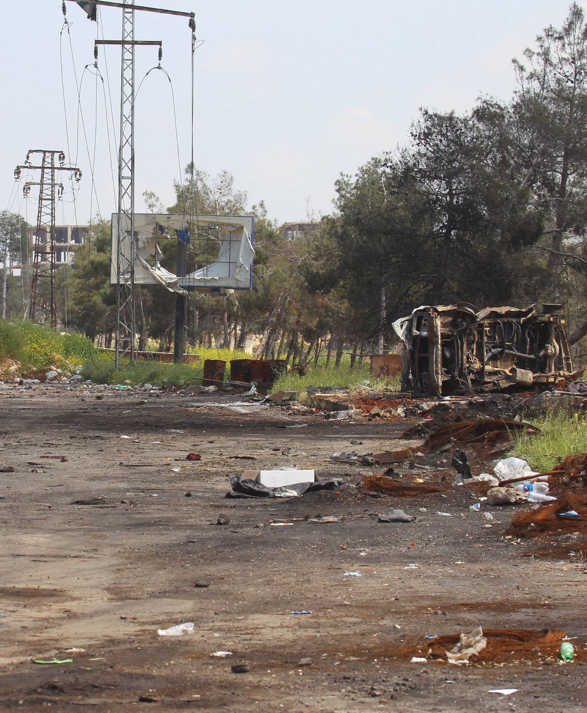 Damaged vehicles are seen after an explosion yesterday at insurgent-held al-Rashideen