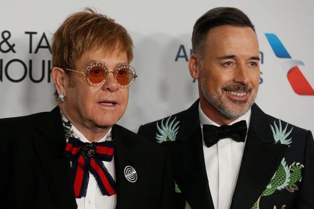 Singer Elton John and his partner David Furnish pose on the red carpet during the commemoration of the Elton John AIDS Foundation 25th year fall gala at the Cathedral of St. John the Divine in New York City