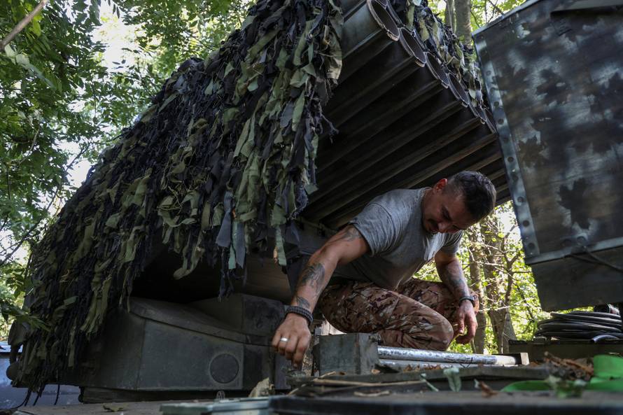A Ukrainian serviceman checks a BM-21 Grad multiple rocket launch system at a position in a front line near the town of Bakhmut