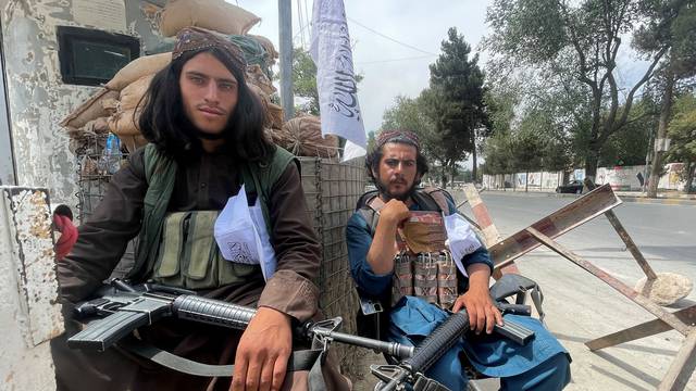 Members of Taliban forces sit at a checkpost in Kabul