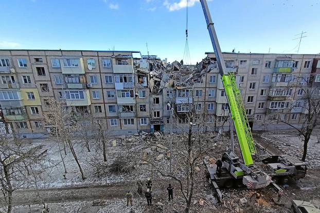 Rescuers remove debris from a residential building damaged by an airstrike in Kharkiv