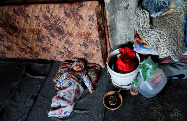 A child lies in a classroom at an UNRWA school where displaced Palestinian Majed al-Bareem and his family shelter, in Khan Younis, in the southern Gaza Strip