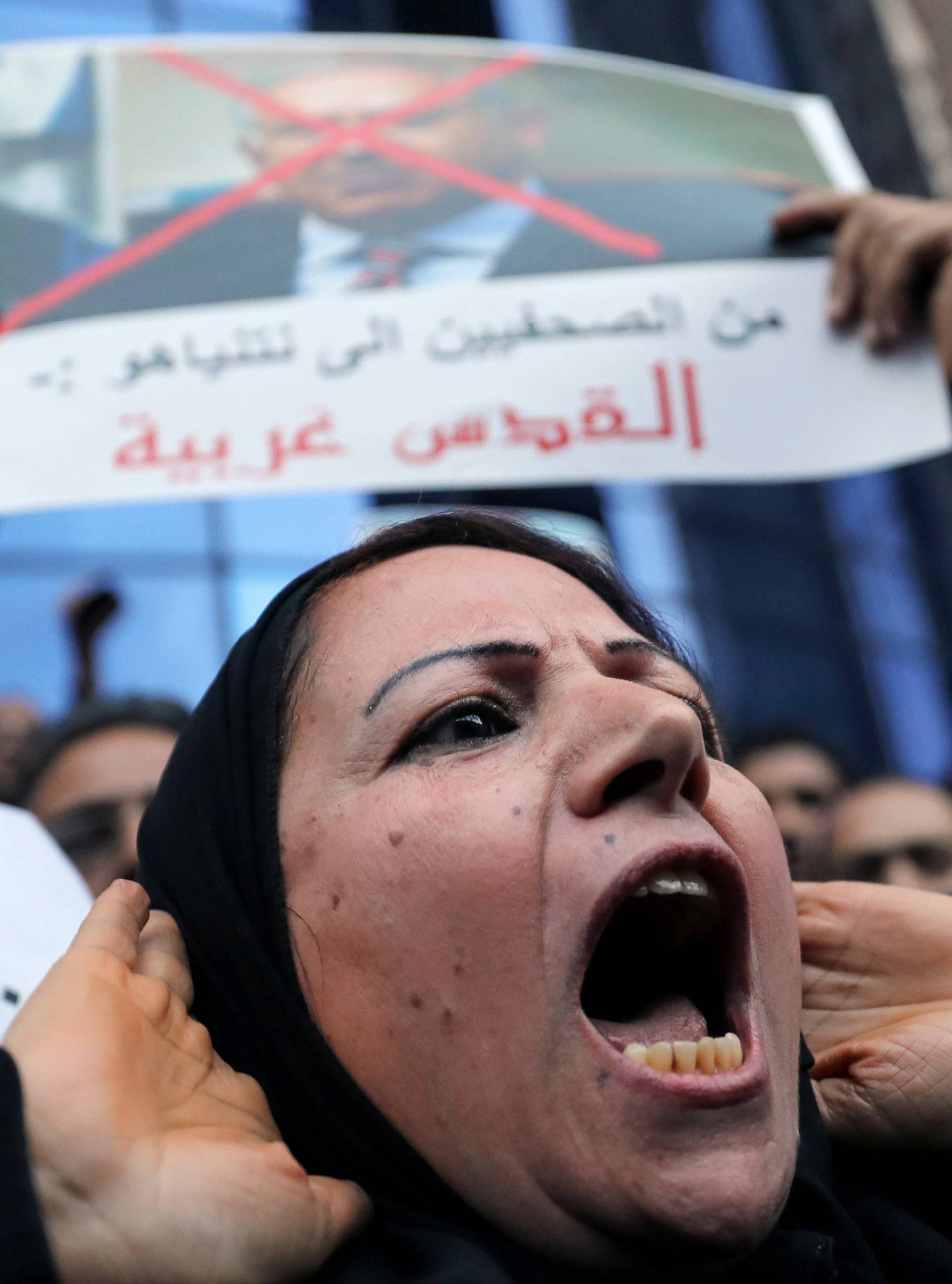 People hold posters condemning Egyptian President Al-Sisi and Trump during a protest against Trump's Jerusalem declaration, in front of the Syndicate of Journalists in Cairo