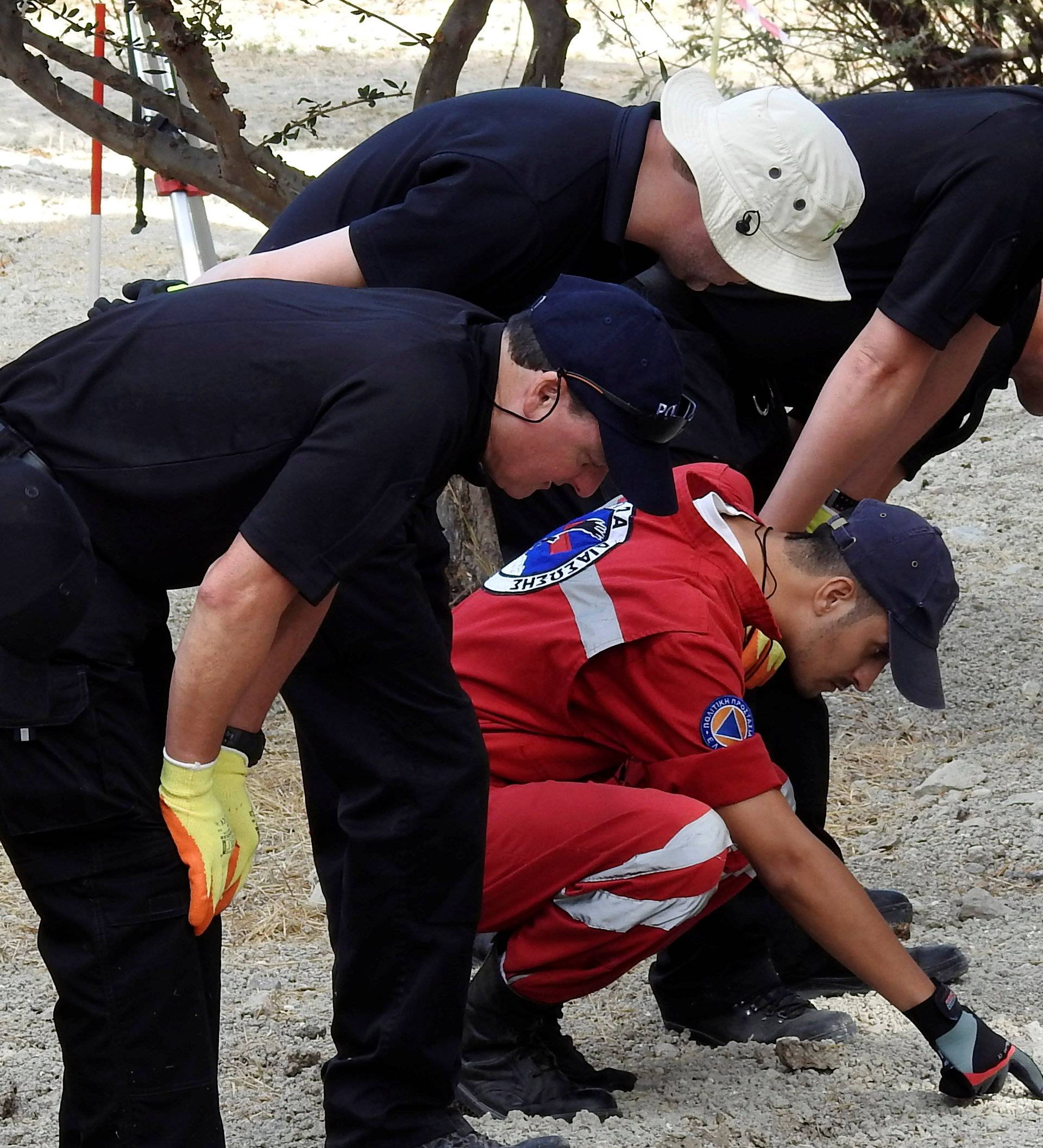 South Yorkshire police officers and members of the Greek rescue service (in red uniforms) investigate the ground before commencing excavating a site for Ben Needham, a 21 month old British toddler who went missing in 1991, on the island of Kos