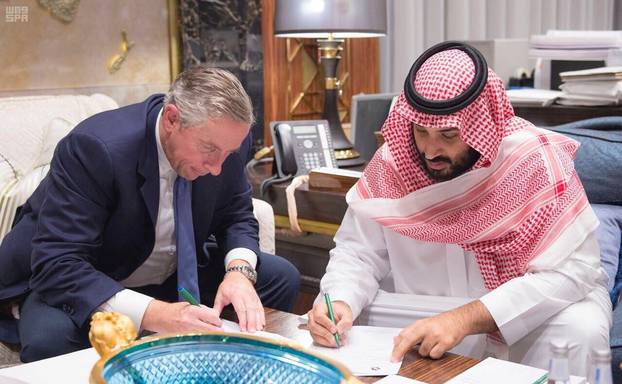 Saudi Crown Prince Mohammed bin Salman and Klaus Kleinfeld sign documents after Kleinfeld was appointed as NEOM
