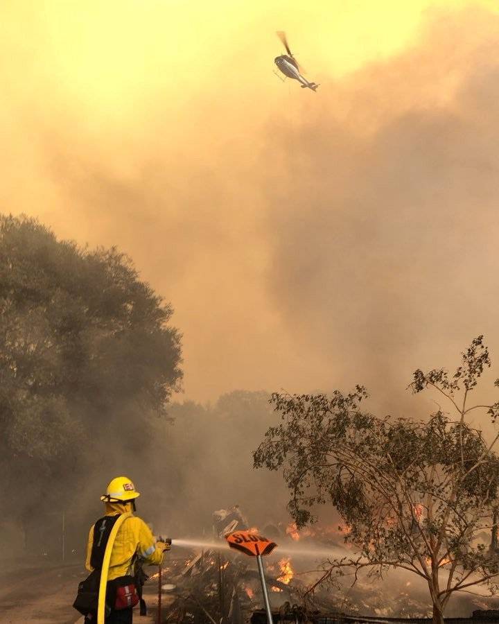 Firefighters battle wildfires as a helicopter hovers above an area near Mendocino National Forest, California