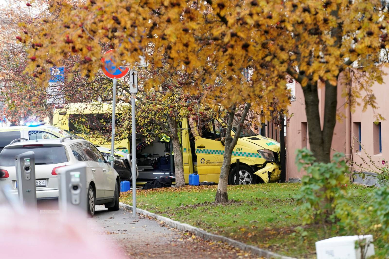 A damaged ambulance stands next to a building after an armed man who stole the vehicle was apprehended by police in Oslo