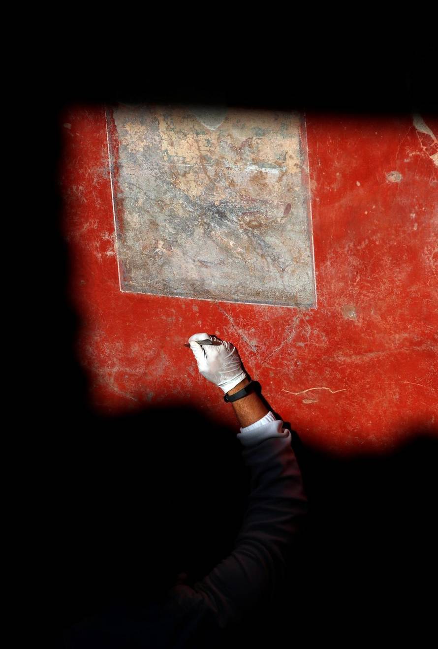 An archaelogist works on a fresco in the House of Lovers "Casa degli Amanti\