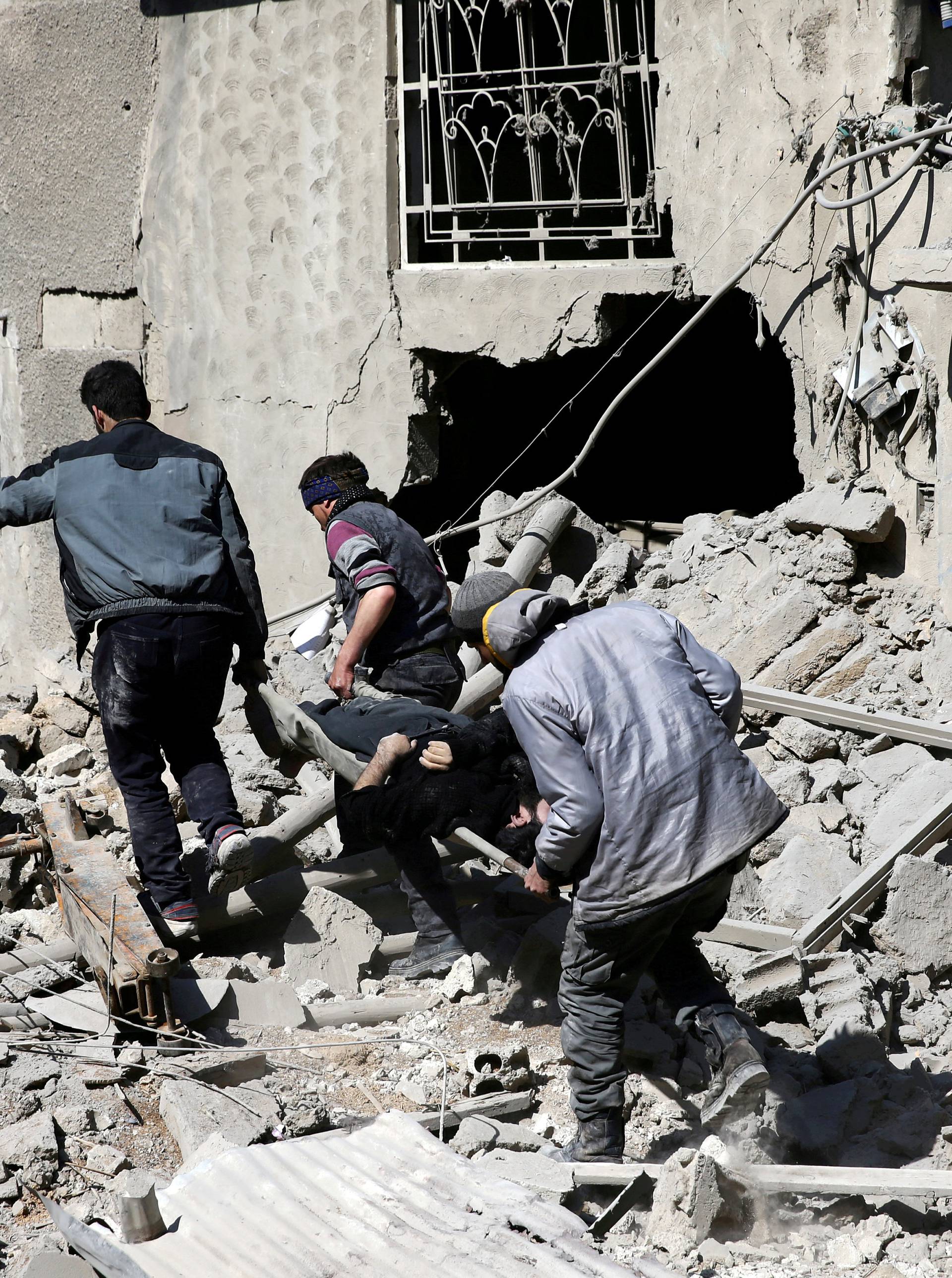 FILE PHOTO: People carry the body of Majid Santiha on a stretcher in the besieged eastern Ghouta town of Hamouriyeh near Damascus