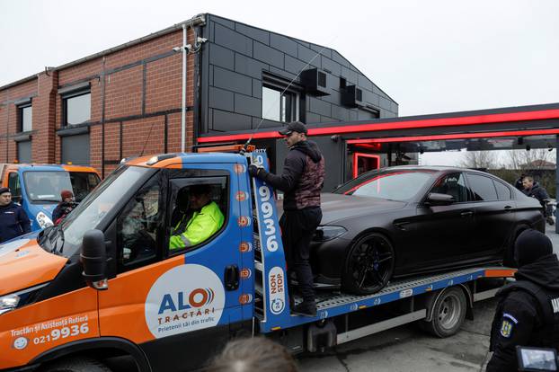 Romanian officials transport the cars seized from the Tate compund to a storage location