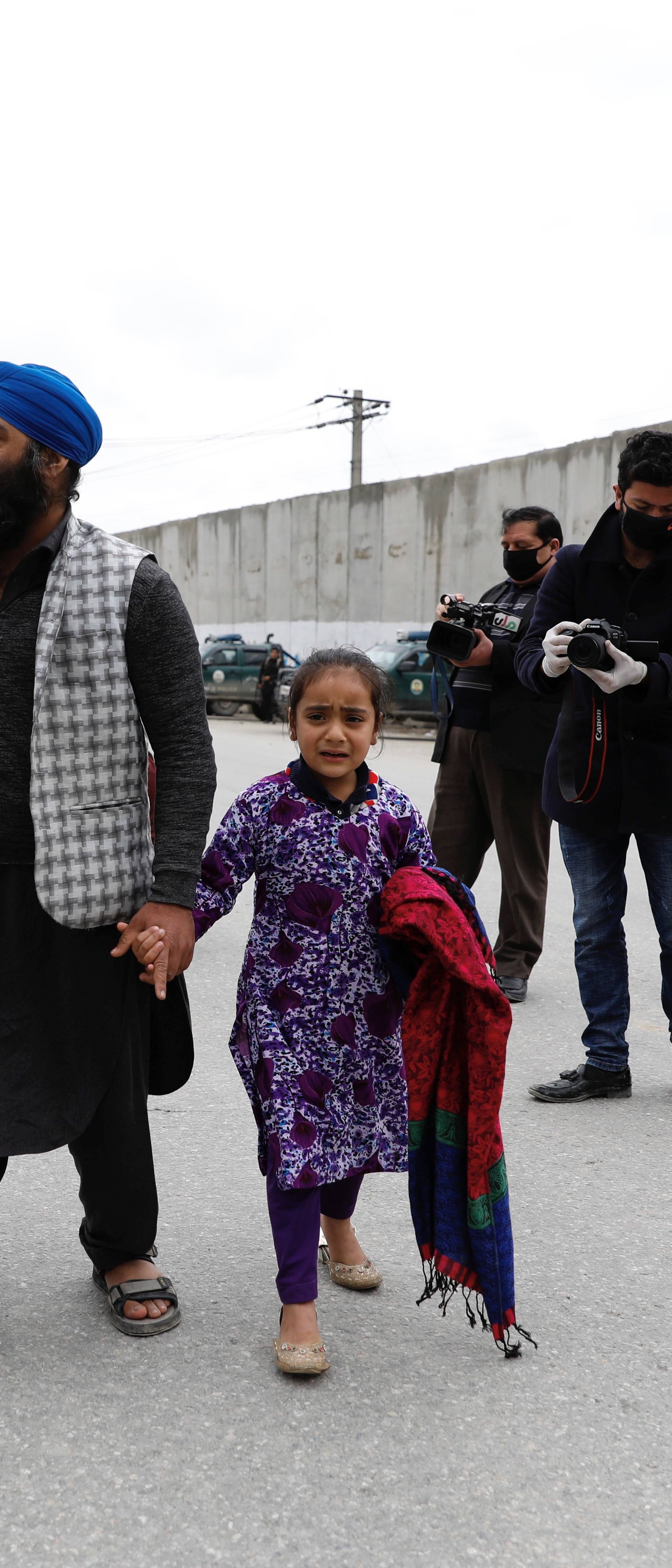 An Afghan Sikh family arrive to see their relatives near the site of an attack in Kabul