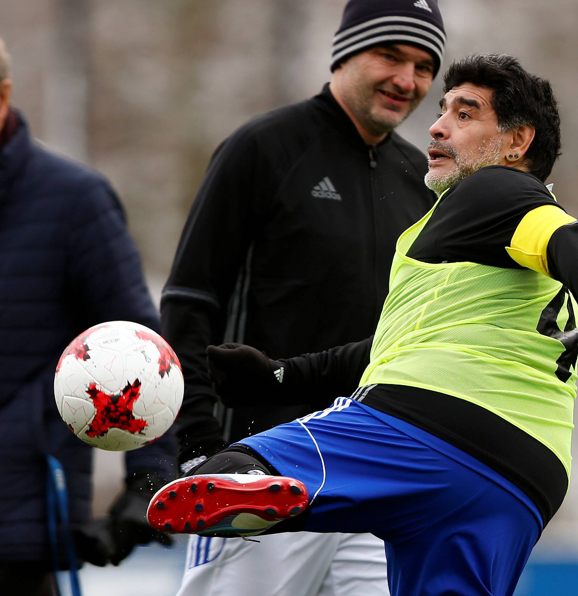 Chapuisat stands behind as Maradona kicks a ball before the FIFA Legends tournament in Zurich