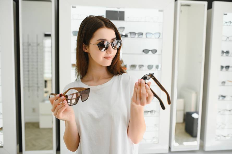 A,Young,Woman,Chooses,On,Sunglasses,In,An,Optics,Store.