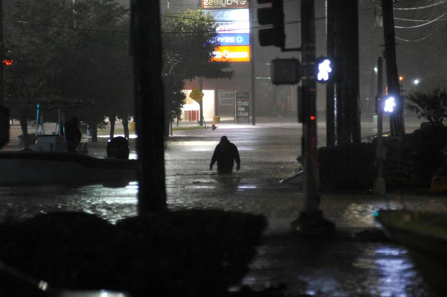 A man wades through floodwater after Hurricane Harvey inundated the Texas Gulf coast with rain causing widespread flooding, in Houston