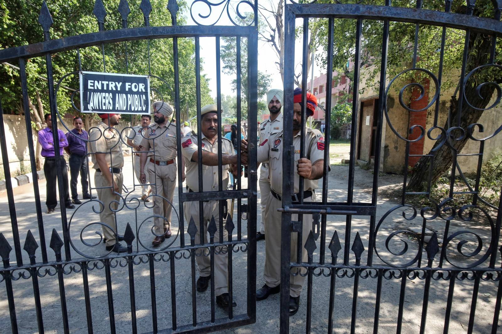 Police officers stand guard before the verdict on rape and murder of an eight-year-old girl in Kathua, near Jammu, inside a court premises in Pathankot