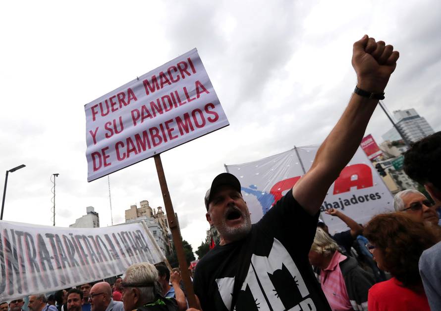 A man shouts slogans as he holds a sign during a protest against a cost increase in public and utility services in Buenos Aires