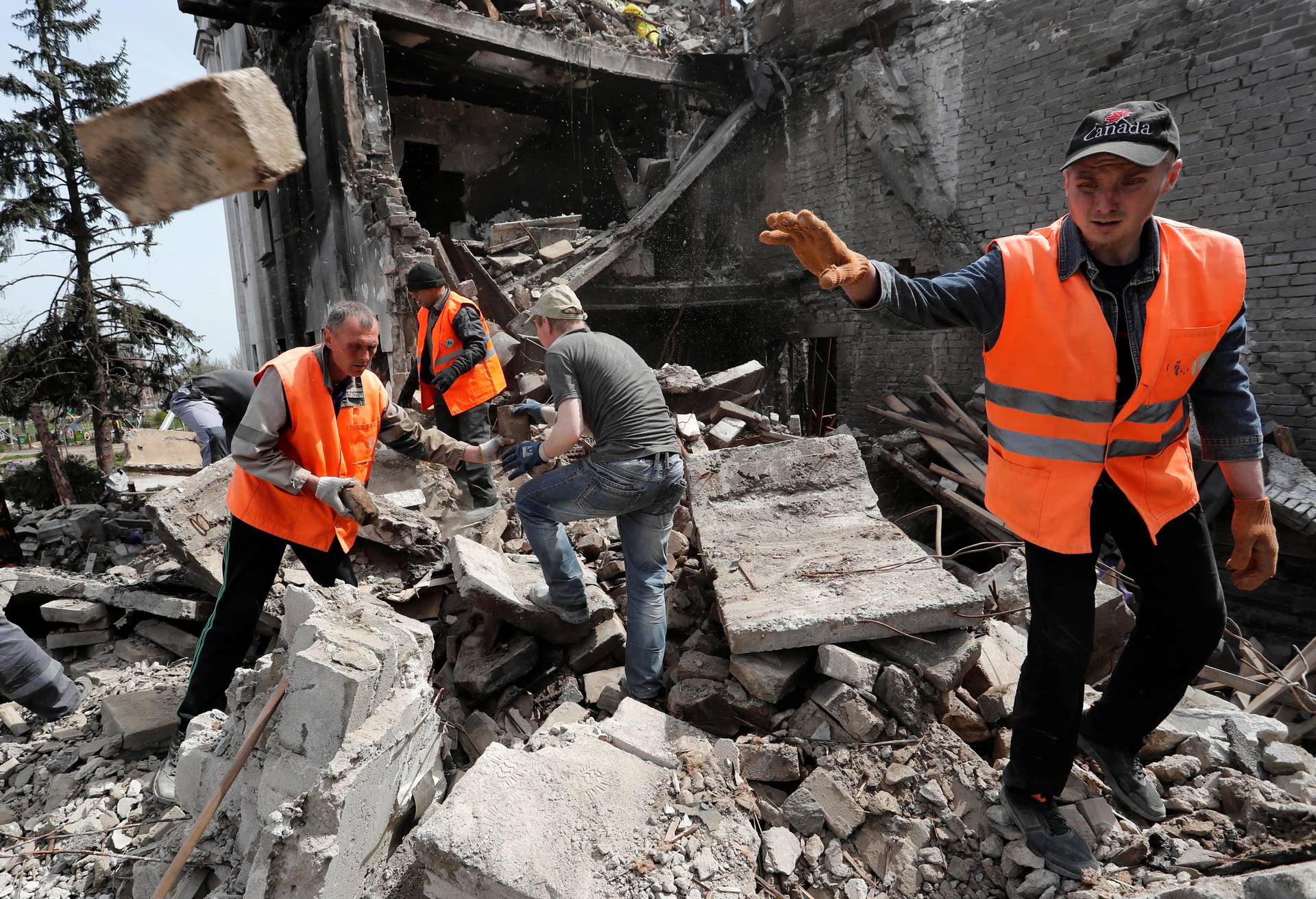 People remove the debris of a theatre building in Mariupol