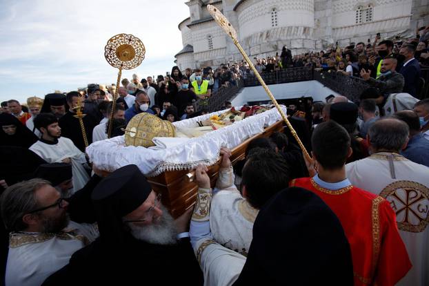 Priests take coffin of Metropolitan Amfilohije Radovic into burial chamber in Podgorica