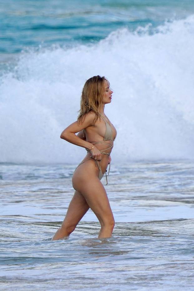 Kimberley Garner doing a photoshoot on a beach with fashion photographer Camellia Menard during holiday season in St-Barth