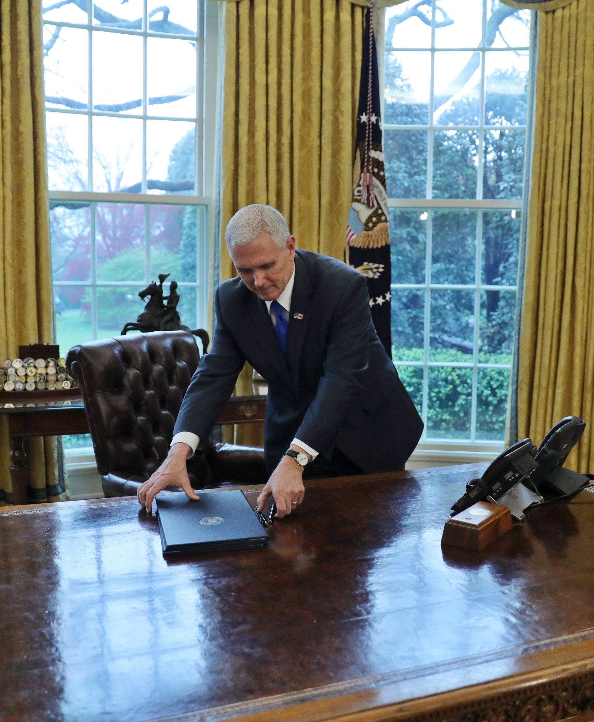 Vice President Mike Pence holds two executive orders on trade scheduled to be signed by U.S. President Donald Trump during a schedule signing ceremony at the Oval Office of the White House in Washington, U.S.