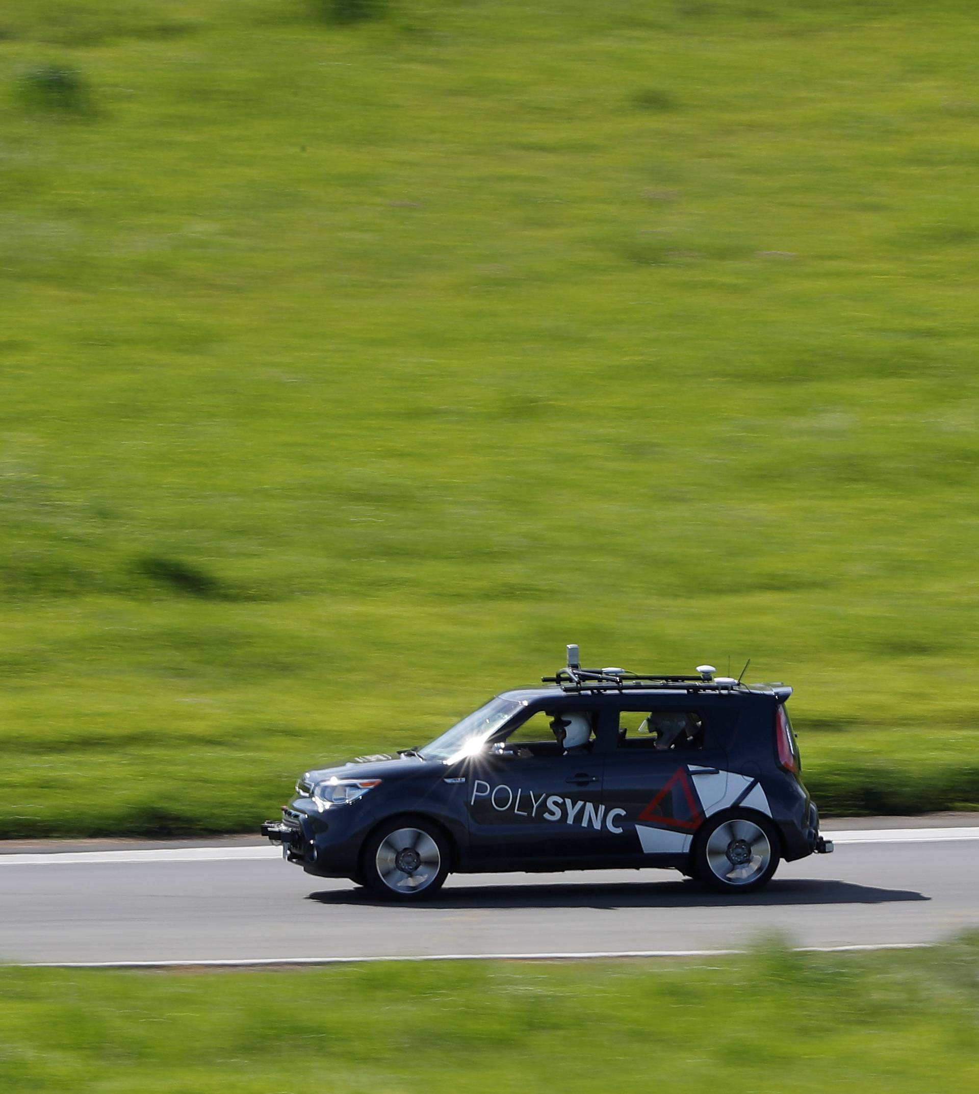 A self-driving car from PolySync drives on the track during a self-racing cars event at Thunderhill Raceway in Willows, California