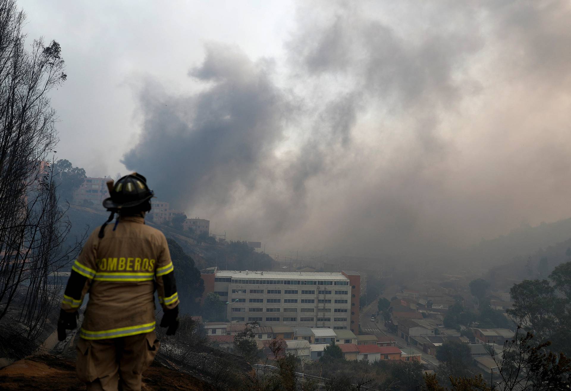 A firefighter stands amid the spread of wildfires in Vina del Mar