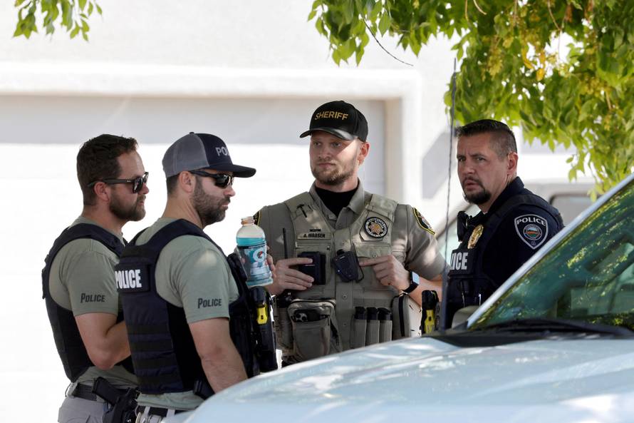 Law enforcement officials investigate at a residence in Washington
