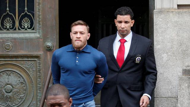 MMA fighter Conor McGregor is escorted by New York City Police (NYPD) detectives from the 78th police precinct after charges were laid against him in New York