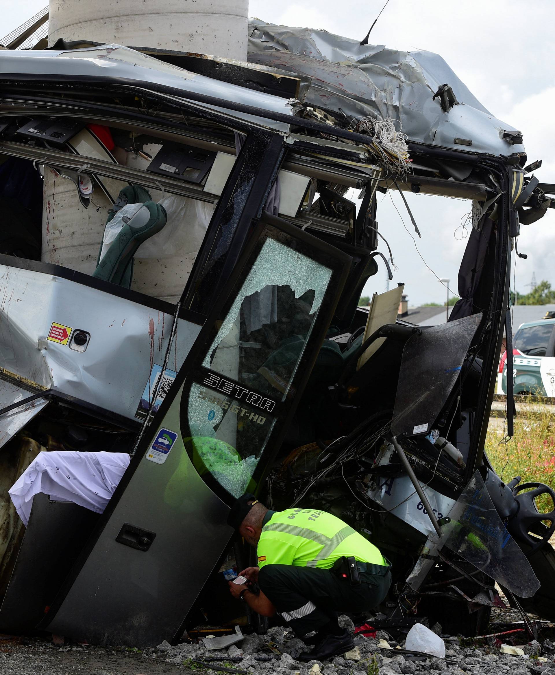 A civil guard surveys the wreckage of a bus crash which left at least four people dead in Aviles