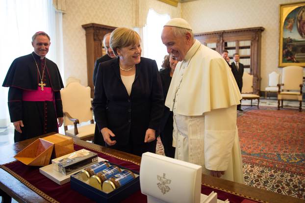 German Chancellor Angela Merkel and Pope Francis exchange gifts during a meeting at the Vatican