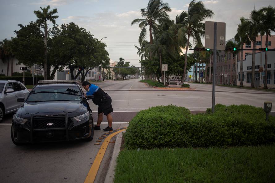 Miami Beach Police Department officers speak at an intersection ahead of the arrival of Hurricane Irma in Miami Beach, Florida