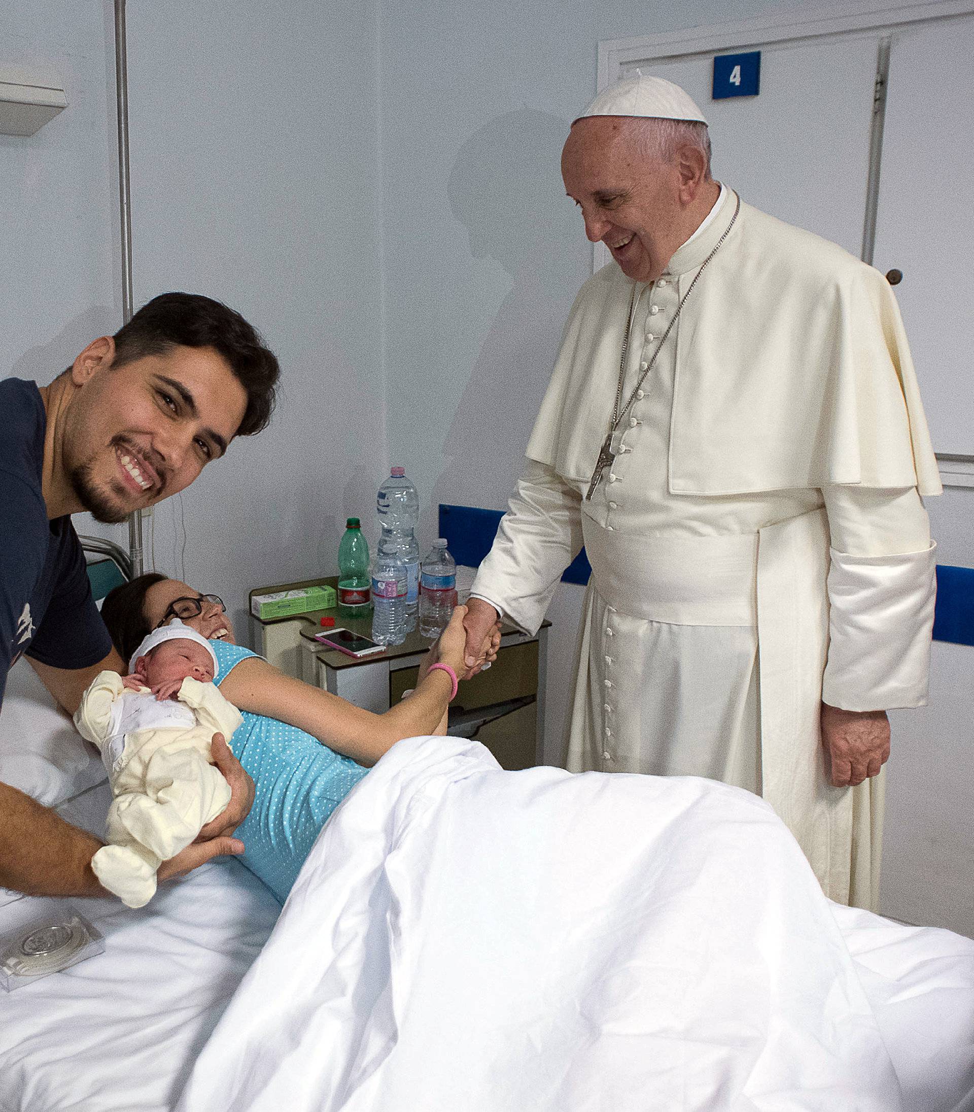 Pope Francis shakes hands to patient as he visits the intensive care nursery at the San Giovanni hospital in Rome