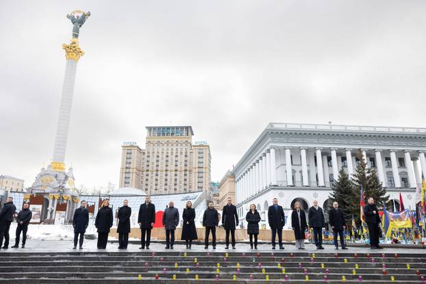 Ukraine's President Zelenskiy his wife Olena and foreign leader visit a makeshift memorial to fallen Ukrainian defenders at the Independent Square on the fourth anniversary of Russia's full-scale invasion, in Kyiv