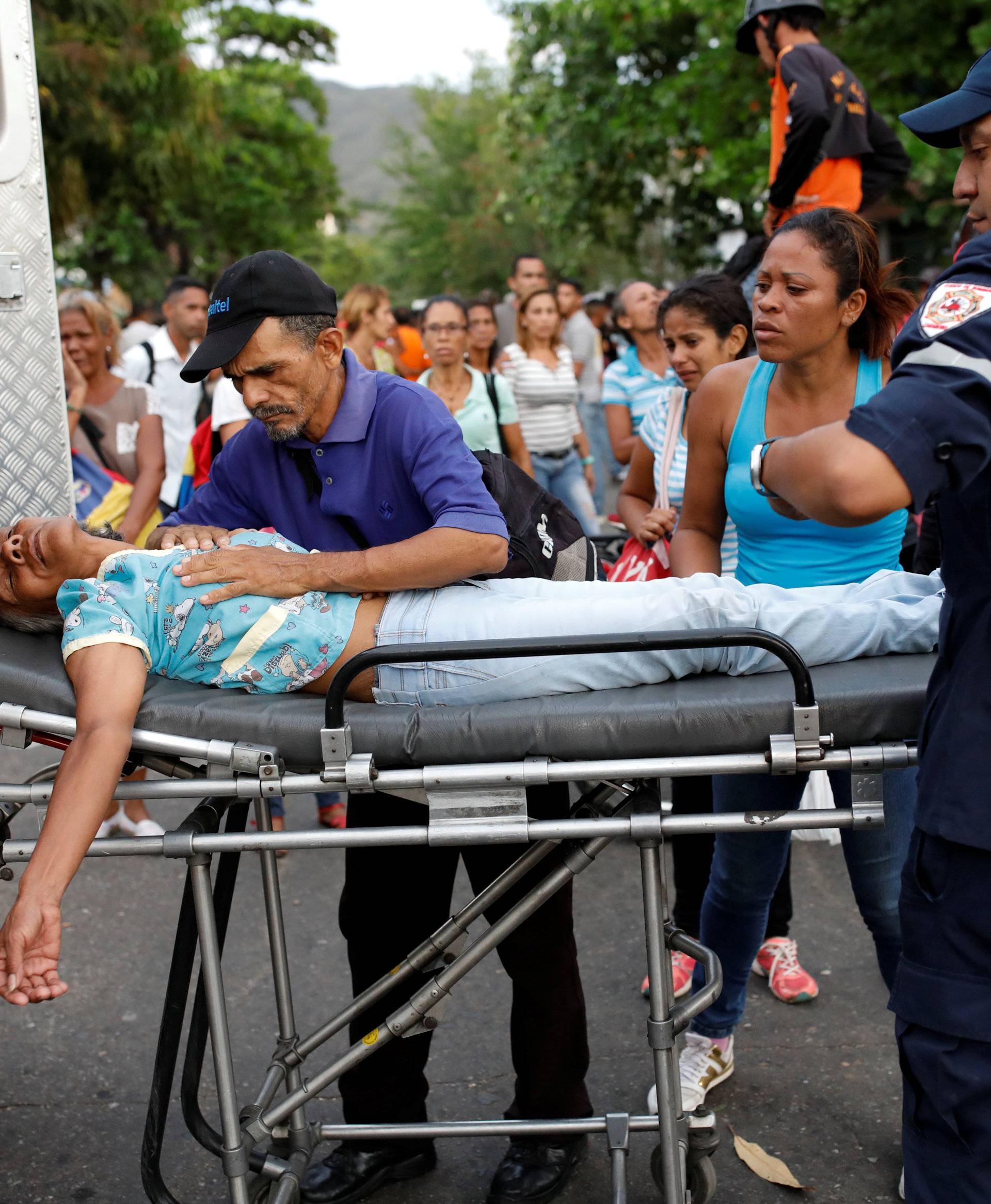 Paramedics help a relative of inmates held at the General Command of the Carabobo Police in Valencia