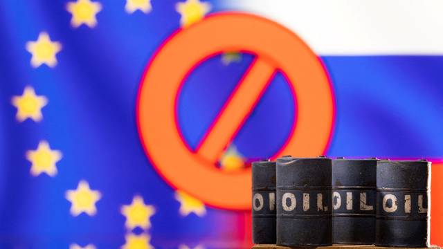 FILE PHOTO: Illustration shows Models of oil barrels in front of sign "stop", EU and Russia flag colours