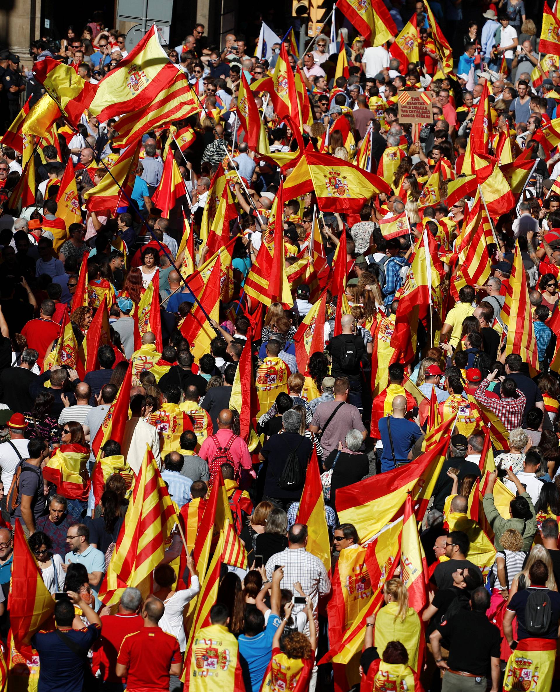 People wave Catalan and Spanish flags as they attend a pro-union demonstration organised by the Catalan Civil Society organisation in Barcelona