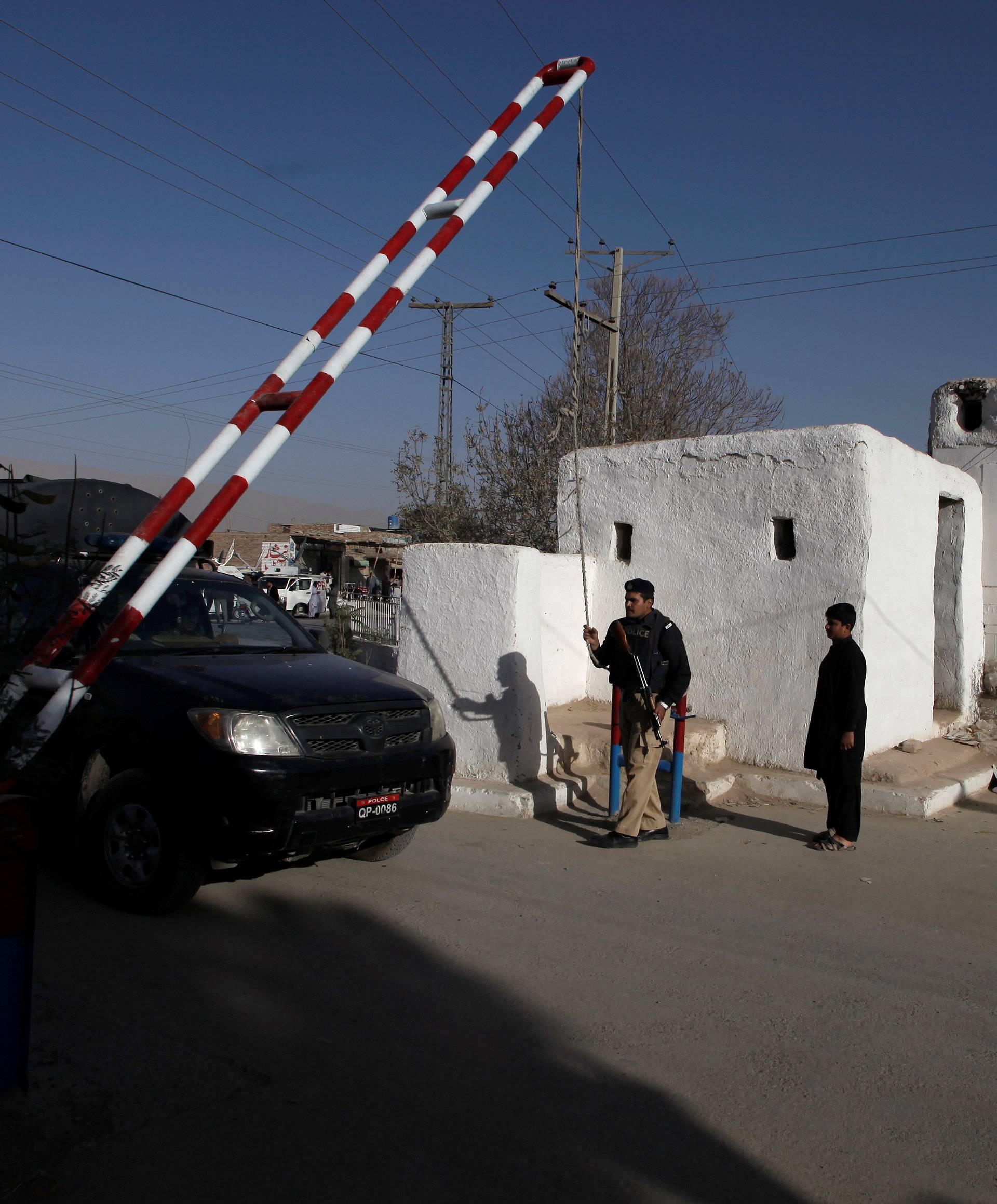 Barriers are raised to allow a police truck into the Police Training Center after an attack on the center in Quetta