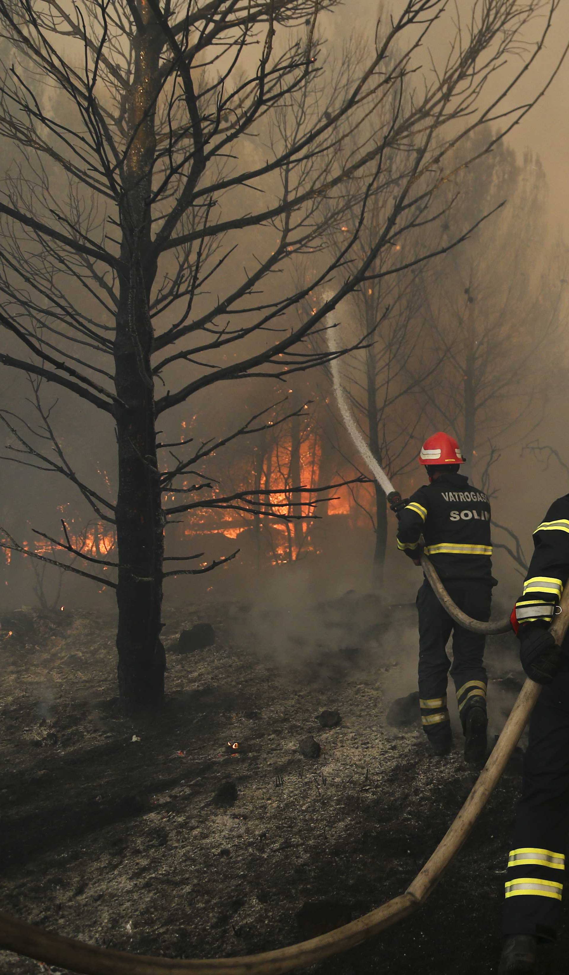 Firefighters try to extinguish a wildfire in the village of Mravince near Split