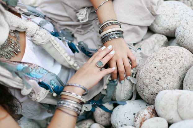 close up of boho styled woman hands with silver jewelry