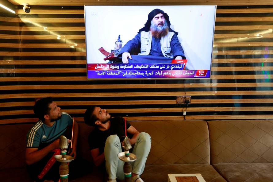 FILE PHOTO: Iraqi youth watch the news of Islamic State leader Abu Bakr al-Baghdadi death, in Najaf