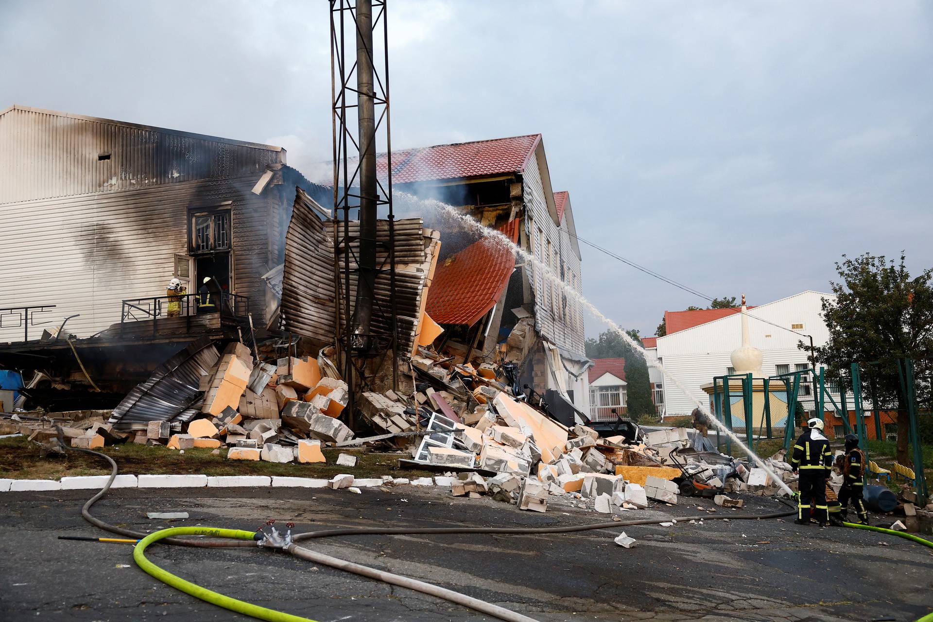 Firefighters work at a site of a sports complex of a university damaged during a Russian missile strike in Kyiv