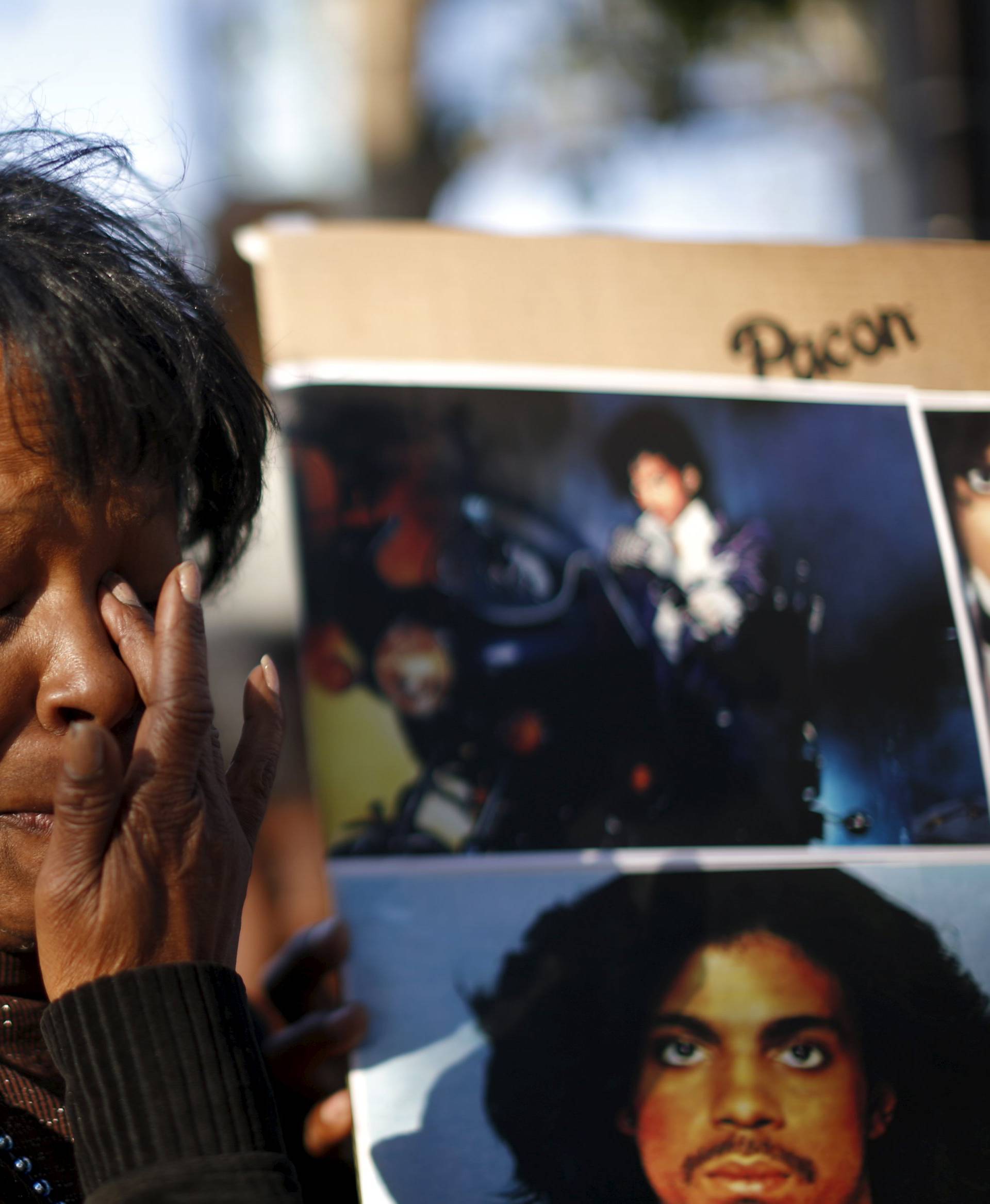 Lorraine Womble wipes her eye at a vigil to celebrate the life and music of deceased musician Prince in Los Angeles