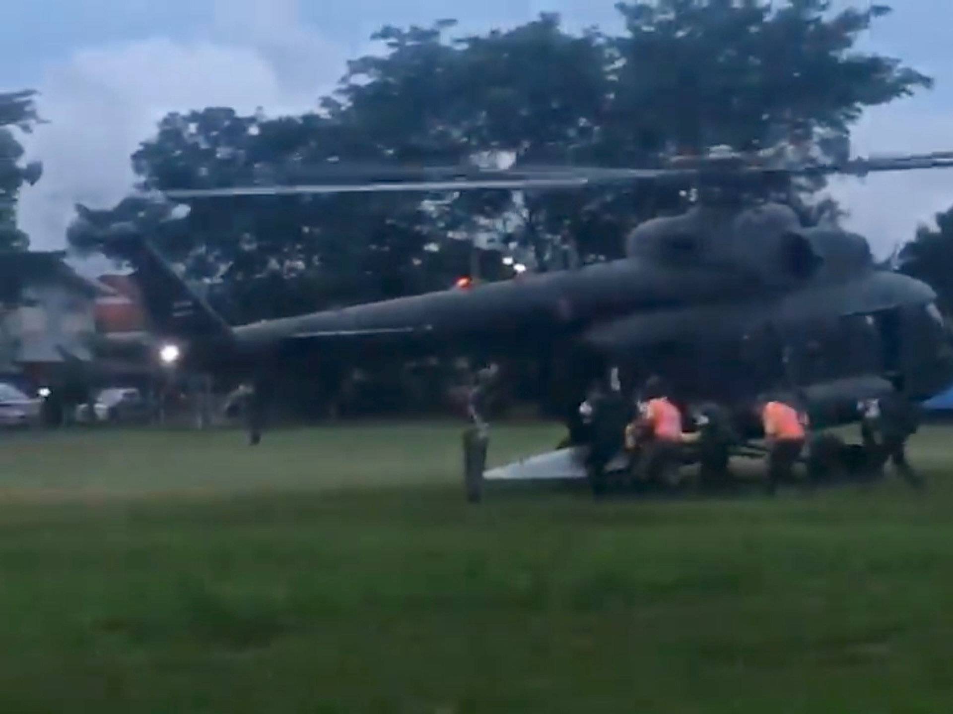 Paramedics, believed to be carrying a boy who has been evacuated after being trapped inside a flooded cave, approach a helicopter in Chiang Rai