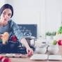 Cooking woman in kitchen with wooden spoon